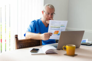 Patient is tensed and reviewing dental bill and insurance statement while evaluating Are Patients Satisfied With Aspen Dental after claims processing