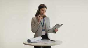 Confident corporate event planner in business-casual attire reviewing a tablet and clipboard with minimal event props on a white background, representing professional event management and ROI-focused planning.