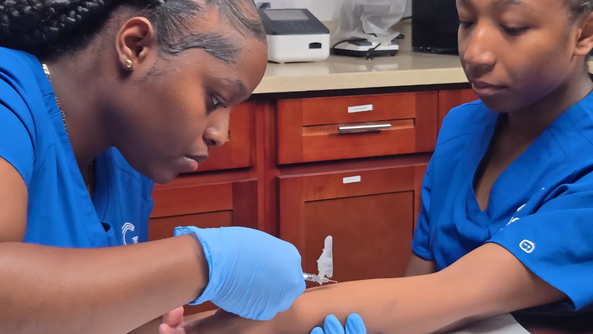 Medical assistant programs student practicing a blood draw in a skills lab